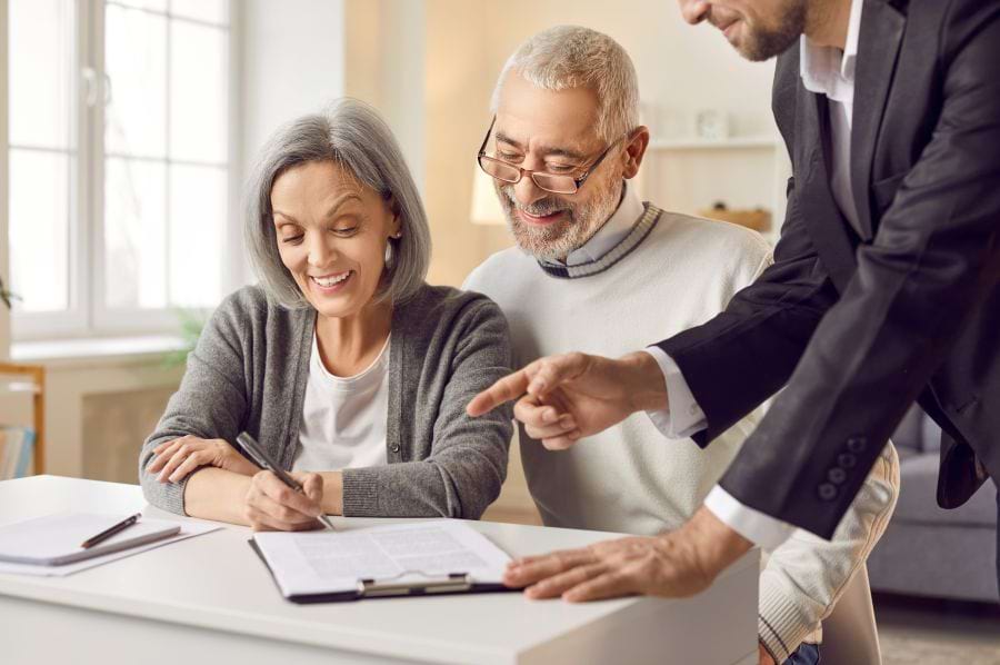 Married couple filling out documents with estate planning lawyer